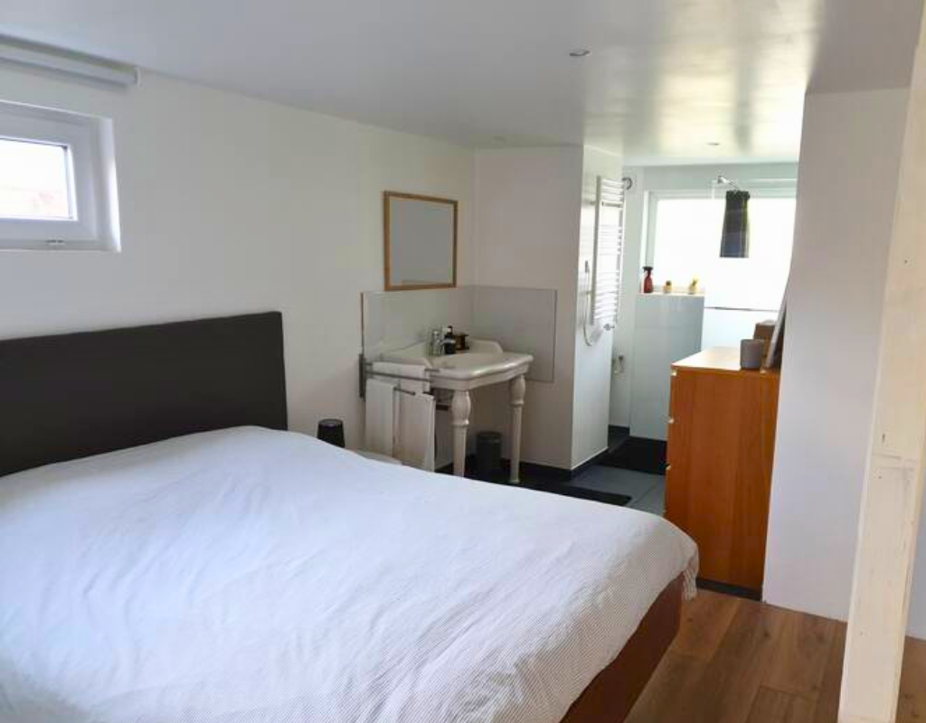 La photo montre la beauté et simplicité de la chambre ainsi que le début de la salle de bain de la Casa Bambù.