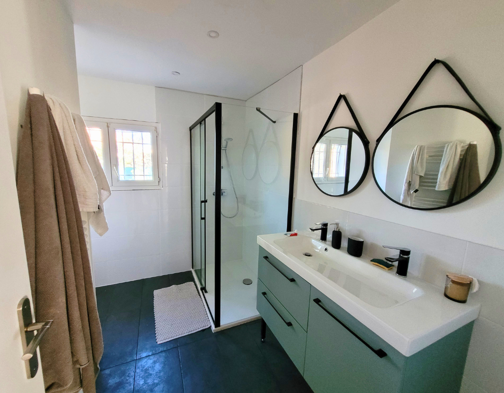 La salle de bain de la maison Caseta, avec ses grands miroirs modernes.